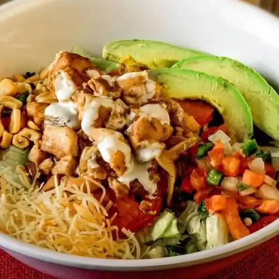 Chicken burrito bowl with avocado, cheese, pico de gallo and rice